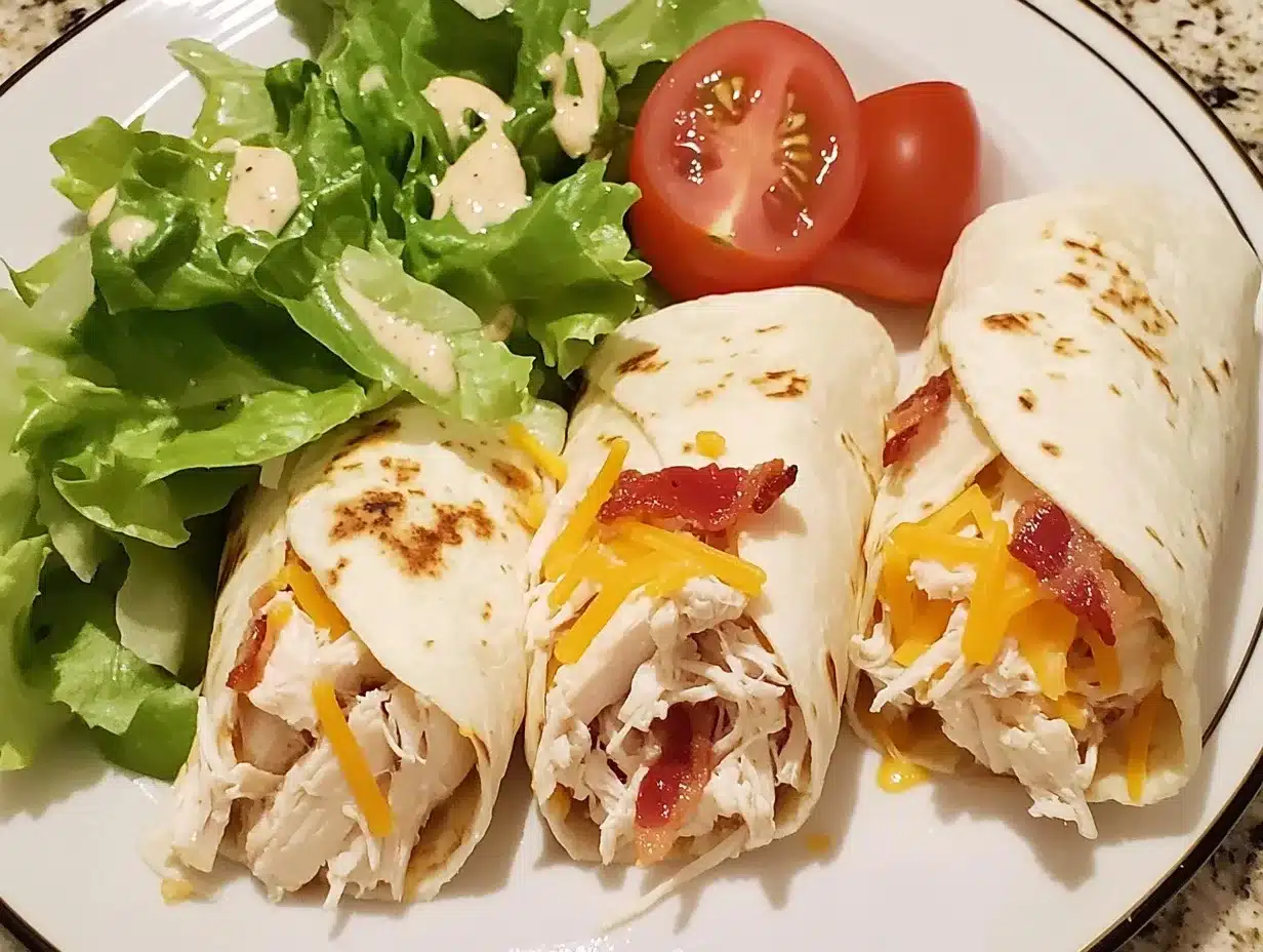 A crispy Chicken Bacon Ranch Wrap filled with juicy chicken, crispy bacon, fresh lettuce, tomatoes, shredded cheddar cheese, and creamy ranch dressing, wrapped in a golden-brown tortilla.