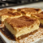 Close-up of a crispy cinnamon sugar churro cheesecake bar showing three distinct layers with cinnamon sugar topping