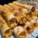 Cross-section view of Bacon Mac 'n' Cheese Taquitos showing creamy mac and cheese filling with bacon pieces