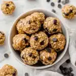 Top-down view of no-bake peanut butter energy bites with visible oats and chocolate chips in a white bowl