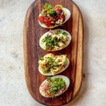 Egg flight recipe featuring four different egg preparations on wooden serving board with fresh herbs and colorful toppings