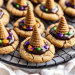 Array of Halloween witch hat cookies with colorful sprinkles on a round cooling rack