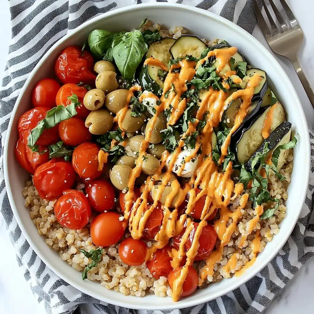 Italian Buddha Bowl with roasted cherry tomatoes, green olives, zucchini slices and orange herb drizzle served over farro grain