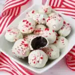 White bowl filled with white-chocolate peppermint Oreo truffles topped with crushed candy canes