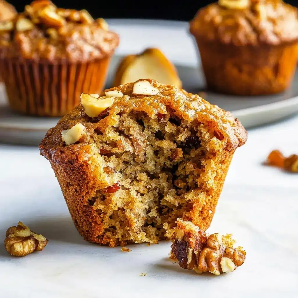 Close-up of a Morning Glory Muffin with perfectly golden exterior showing visible nuts and carrots throughout the crumb