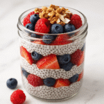 Healthy chia seed pudding parfait with layers of berries and granola from CrennRecipes